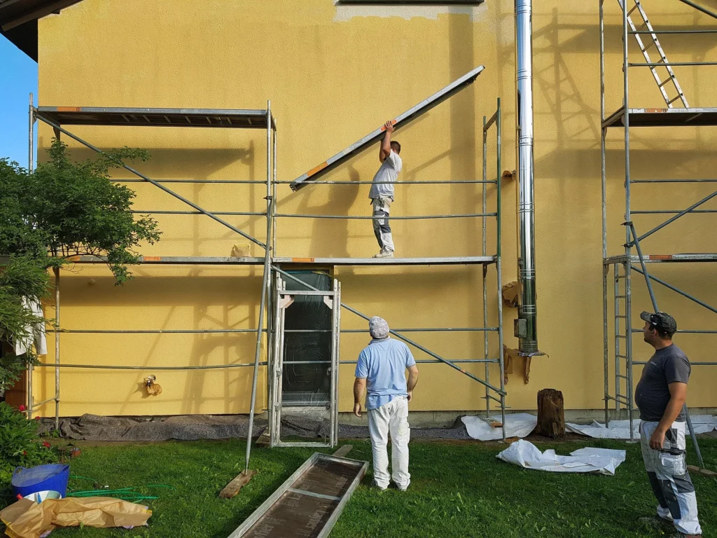 Handwerker bei Sanierungsarbeiten an einer Fassade